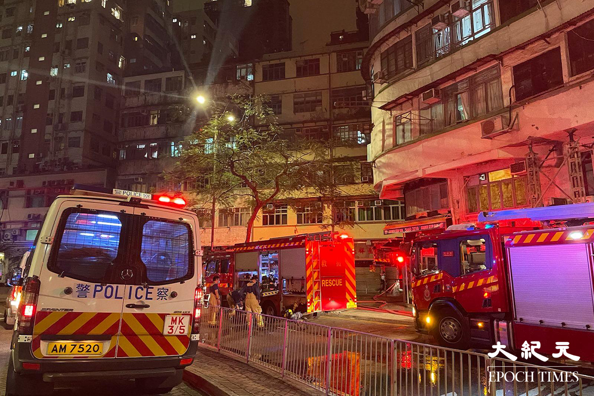 消防接報後派出多輛消防車趕抵現場，並隨即開動一條喉及派出兩隊煙帽隊進入火場灌救，警方將涉事大廈對開一段街道封閉。（卓相如／大紀元）