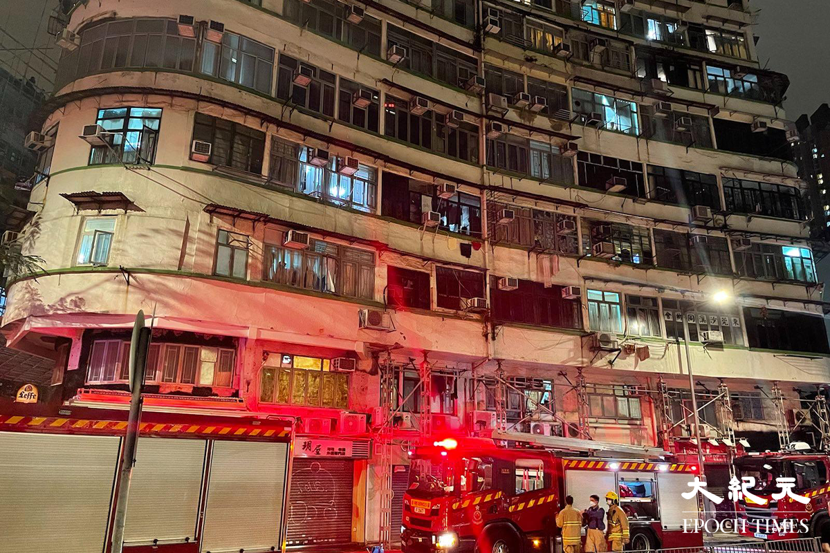 消防接報後派出多輛消防車趕抵現場，並隨即開動一條喉及派出兩隊煙帽隊進入火場灌救，警方將涉事大廈對開一段街道封閉。（卓相如／大紀元）