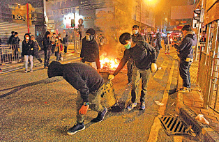 衝突期間,有蒙面示威者向警方投擲垃圾桶、磚塊等雜物。(潘在殊/大紀元)