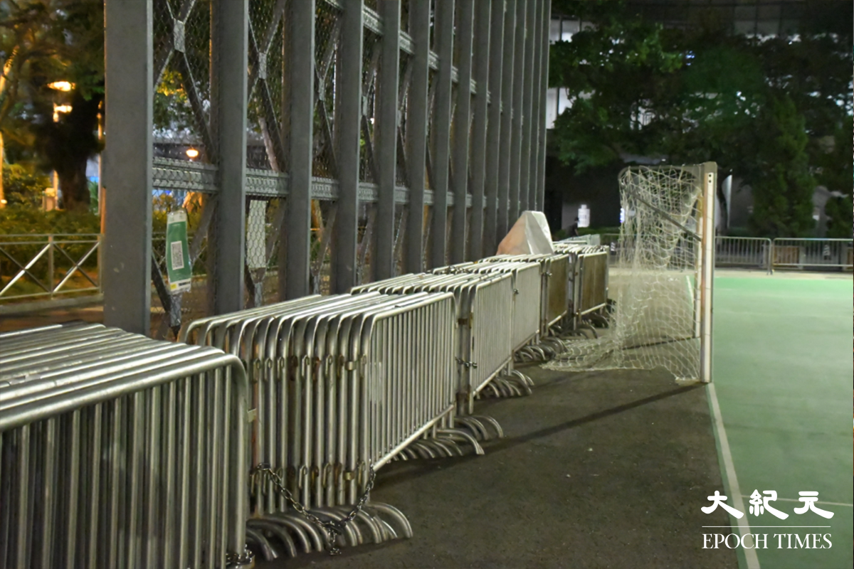維園內的硬地足球場旁邊，突然擺放了多批鐵馬、水馬及「警察」雪糕筒。（麥碧／大紀元）