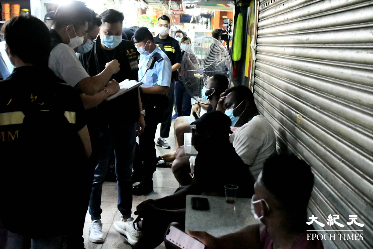 警方於重慶大廈內外，截停搜查多名非華裔人士。（麥碧／大紀元）