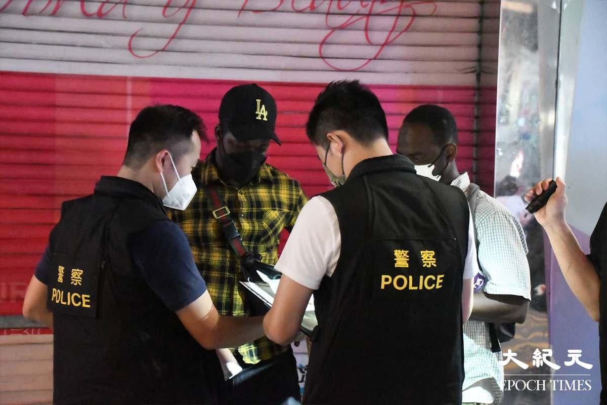 警方於重慶大廈內外，截停搜查多名非華裔人士。（麥碧／大紀元）