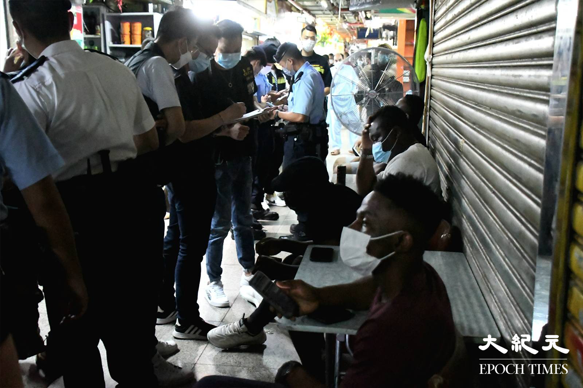 警方於重慶大廈內外，截停搜查多名非華裔人士。（麥碧／大紀元）