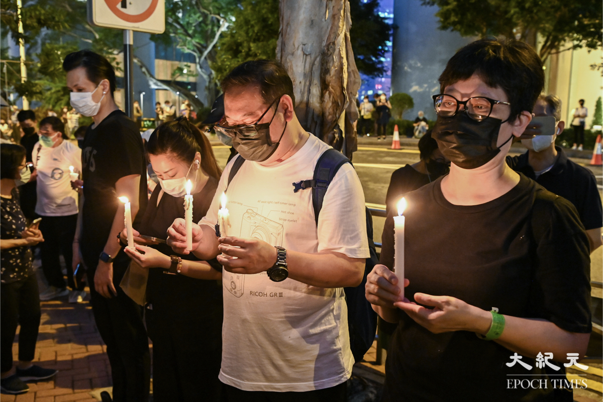入夜後大批市民仍在英領館外悼念英女王，街道上放滿鮮花和蠟燭。（宋碧龍／大紀元）