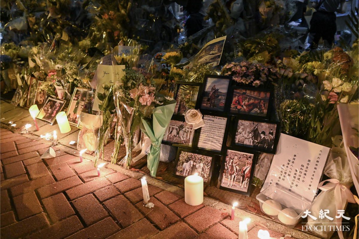 入夜後大批市民仍在英領館外悼念英女王，街道上放滿鮮花和蠟燭。（宋碧龍／大紀元）