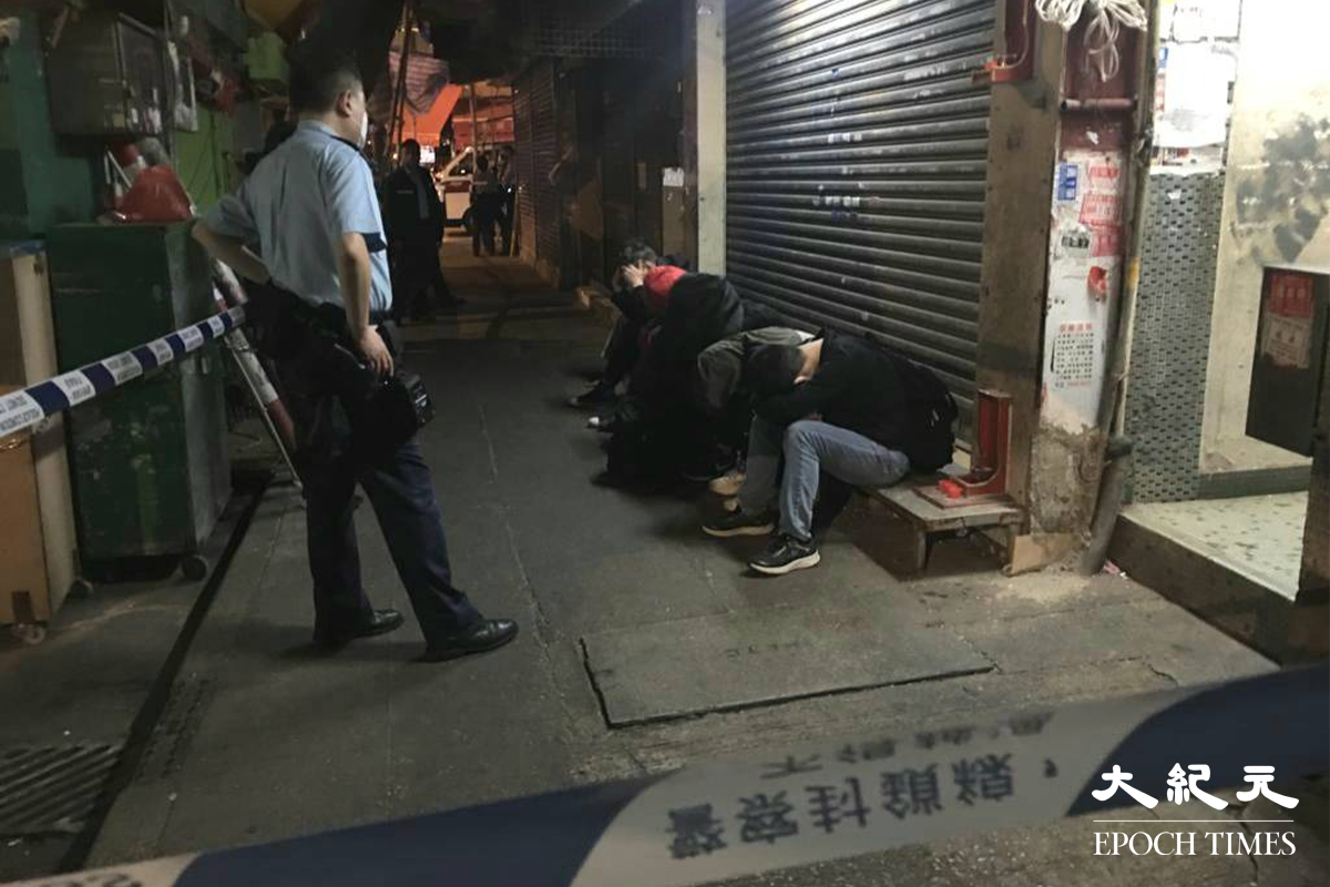 六名男子在警員到場調查期間，攀爬至大廈外牆棚架企圖逃走，最終被留守地面的警員截獲。（劉港業／大紀元）