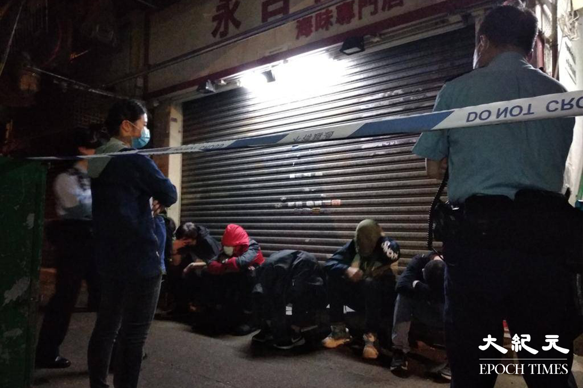 六名男子在警員到場調查期間，攀爬至大廈外牆棚架企圖逃走，最終被留守地面的警員截獲。（劉港業／大紀元）