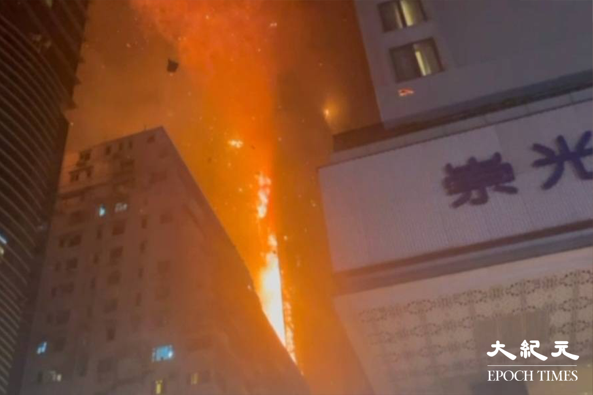 凌晨一時左右，現場火勢仍然相當猛烈，更不時傳出爆炸聲，火屑伴隨雜物不斷掉到街上。（卓相如／大紀元）
