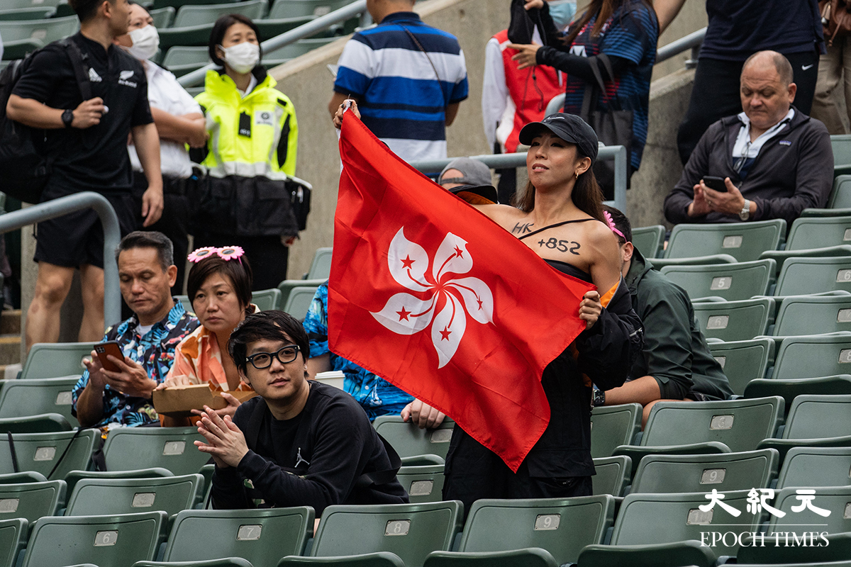 有港隊支持者舉起區旗表達支持。（劉駿軒／大紀元）