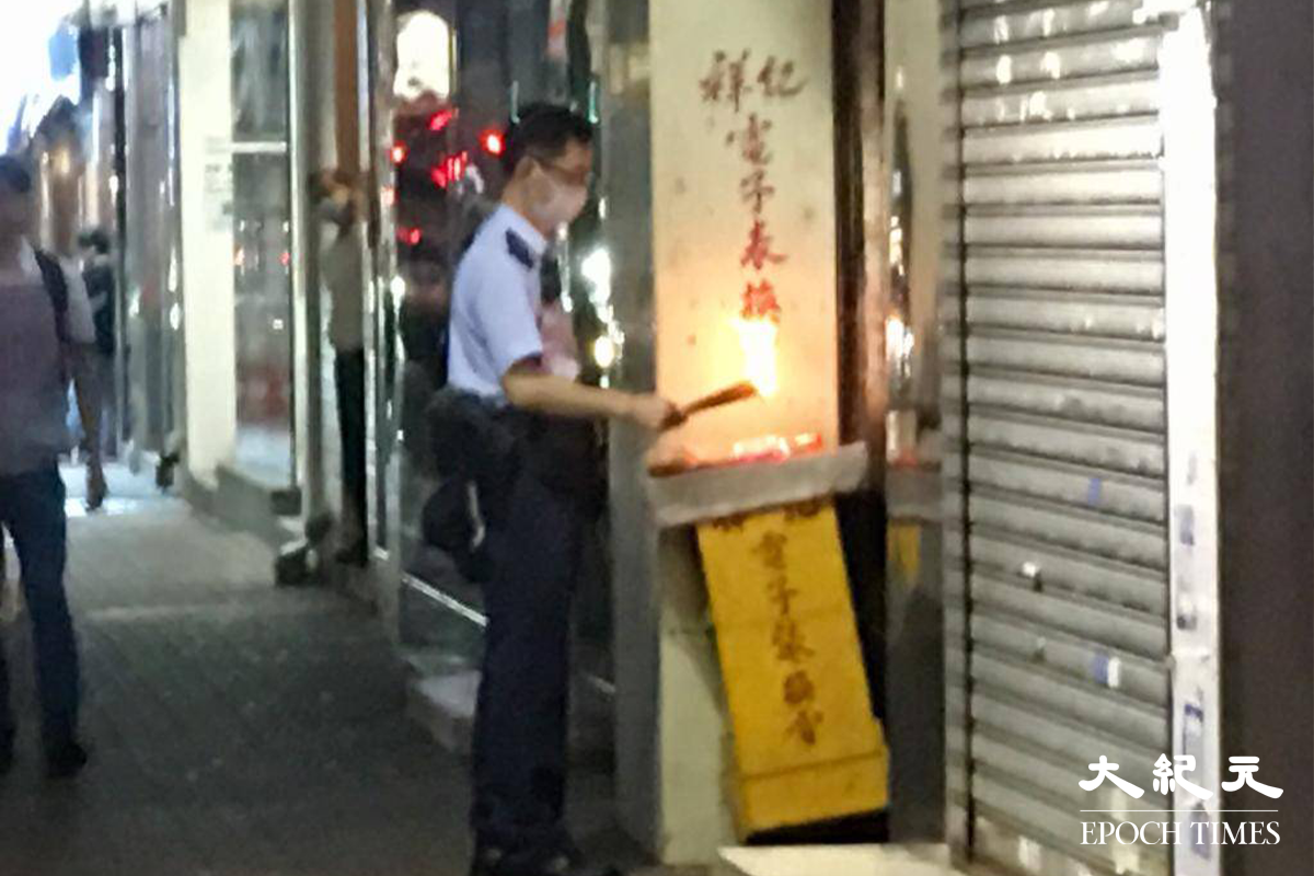 由於屍臭味太濃烈，有警員在涉案唐樓樓梯外焚香闢味。（佘實菁／大紀元）