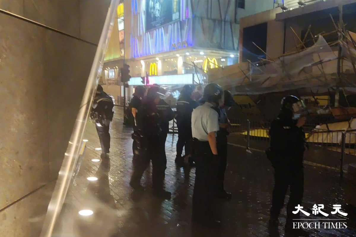 旺角砵蘭街近奶路臣街一棟大廈外牆，一幅約30米乘10米的棚架被強風吹倒棚架晚上塌下，砸毁一輛停泊上址的私家車，現場未接獲傷亡報告。（林建翔／大紀元）